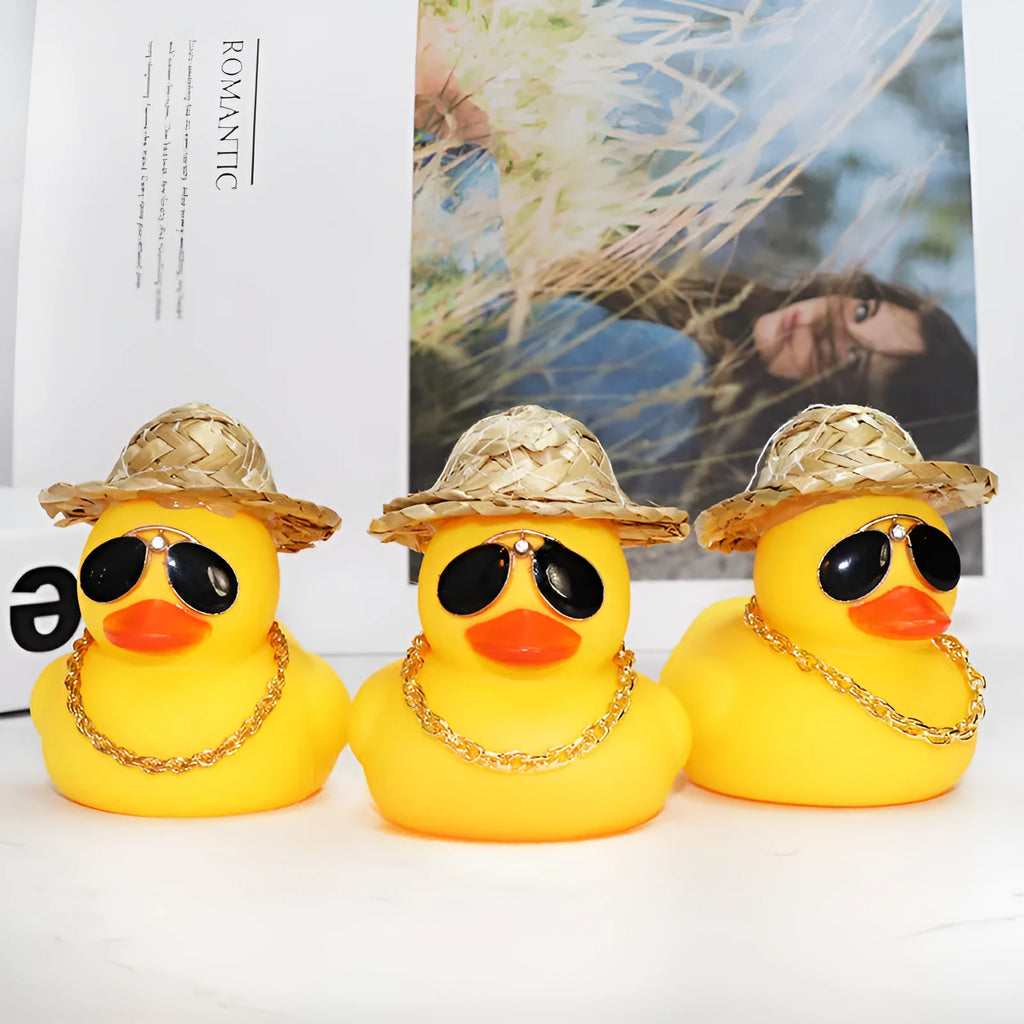 Straw hat yellow duck car ornament with adhesive gel and miniature sunglasses accessory on car dashboard