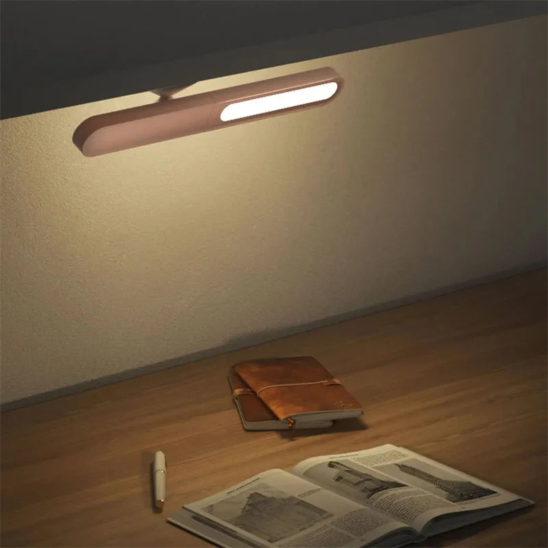 White geometric desk lamp with magnetic base mounted on a metal wall surface.