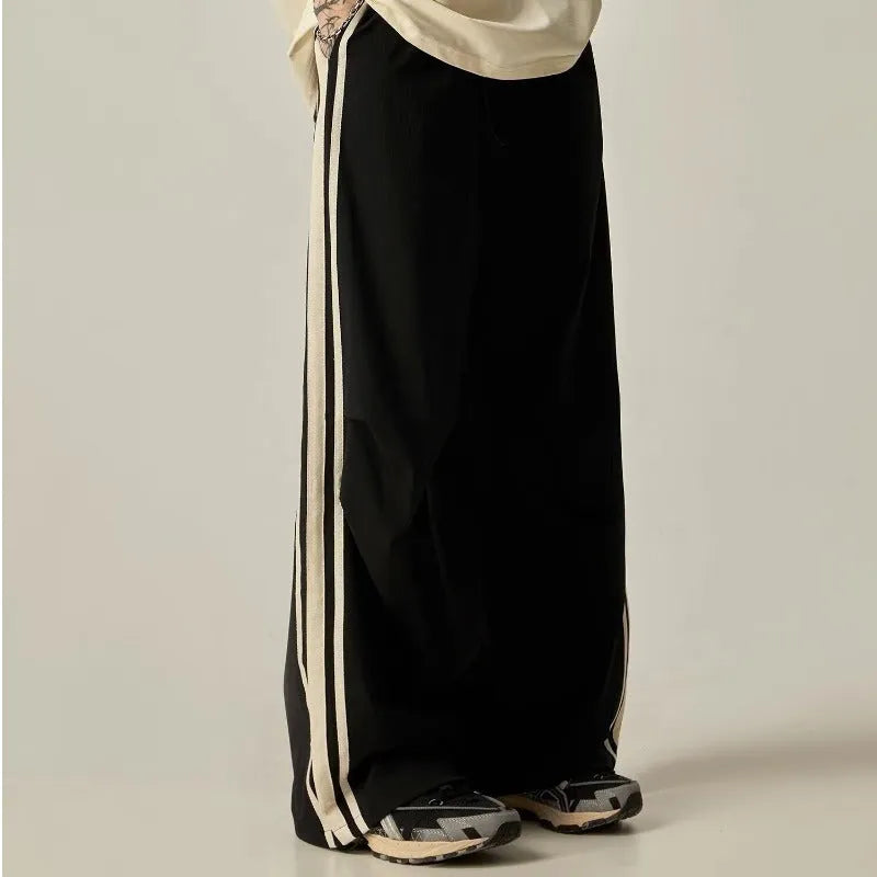 Black wide-leg straight-cut men's climbing trousers with a high waist on a hanger.