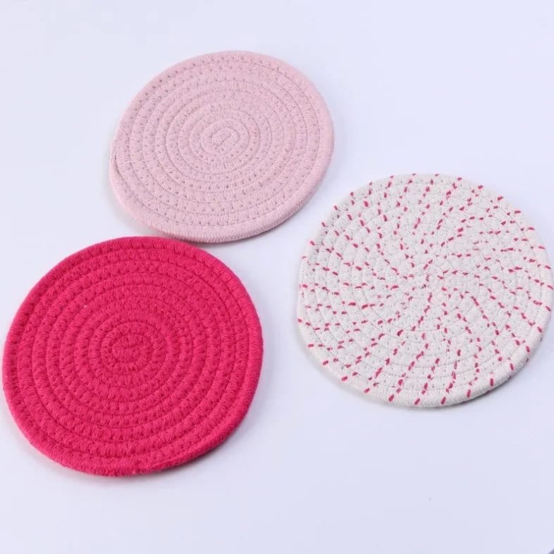 Three round cotton cord coasters in blue, measuring 18cm diameter, on wooden table