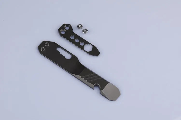 Titanium alloy multi-tool with crowbar edge, screwdriver tip, and bottle opener notches on a stone wash finish background.