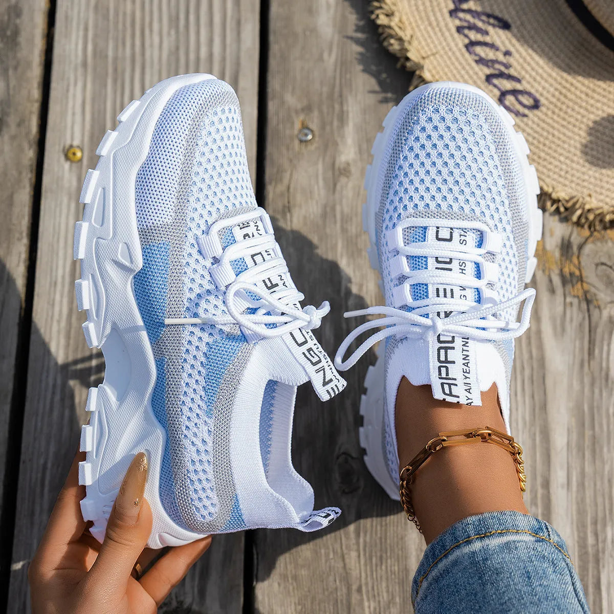 Women's Flyknit mesh lace-up sneakers in grey and white with a low rubber sole.