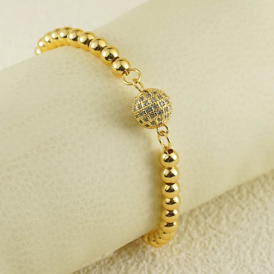 Close-up of a women's copper bracelet with a heart shape design and round zircon stone accents in an Arabic style.