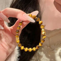Natural yellow tiger's eye stone bracelet showing golden gourd, bamboo joint, and lace pattern variations