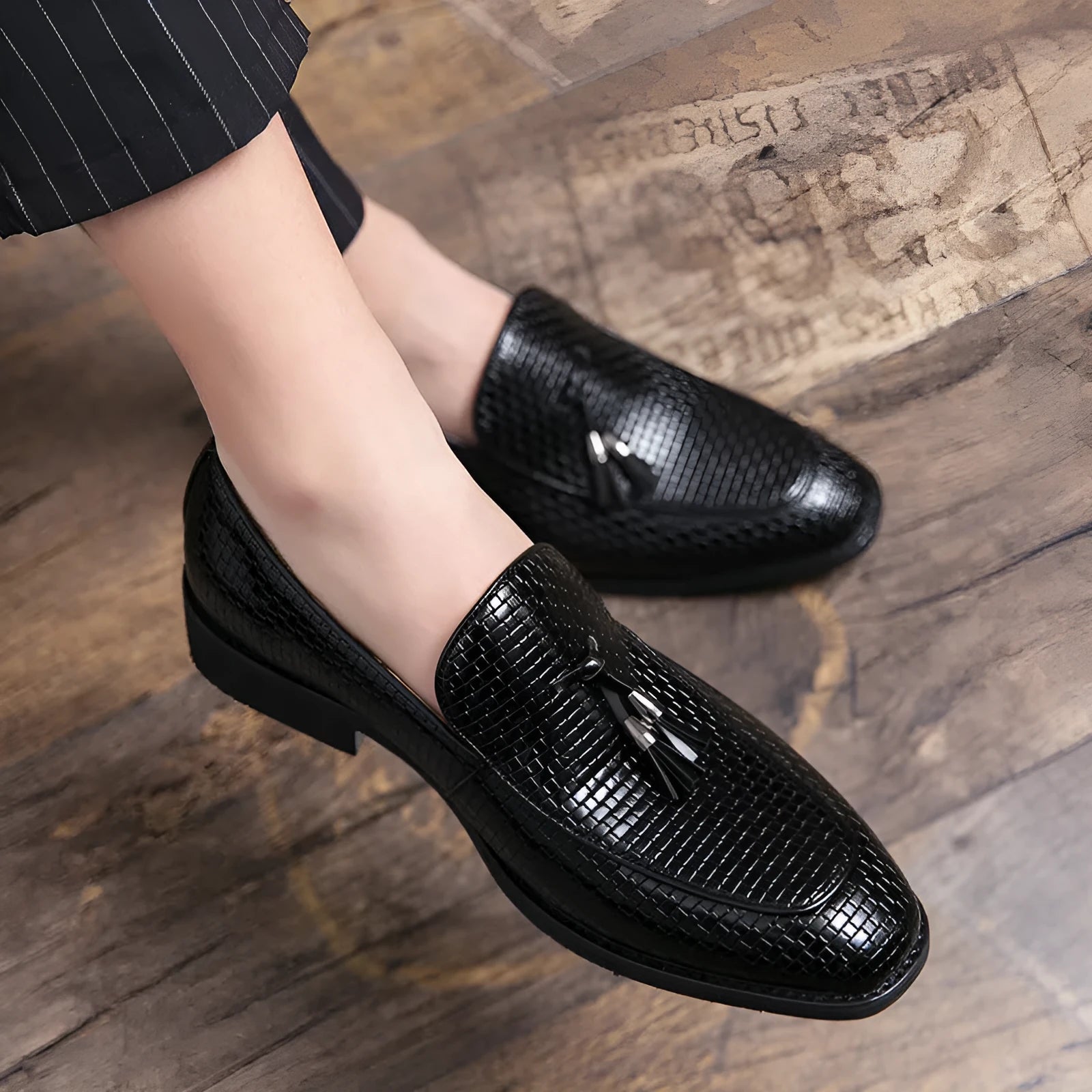 Men's black pointed toe slip-on shoe with a tassel on the low-top PU upper.