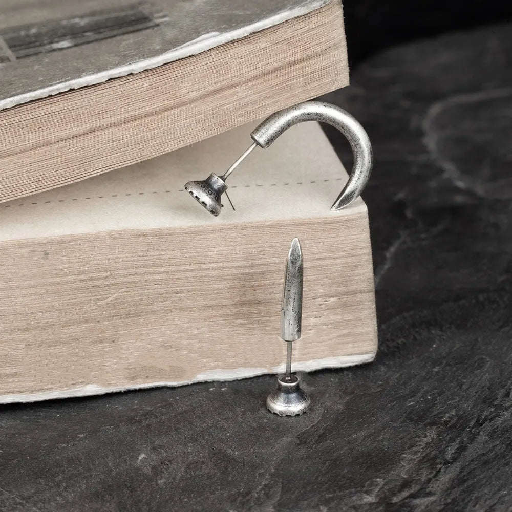 S925 sterling silver nail stud earrings in straight and curved punk designs on a plain background.