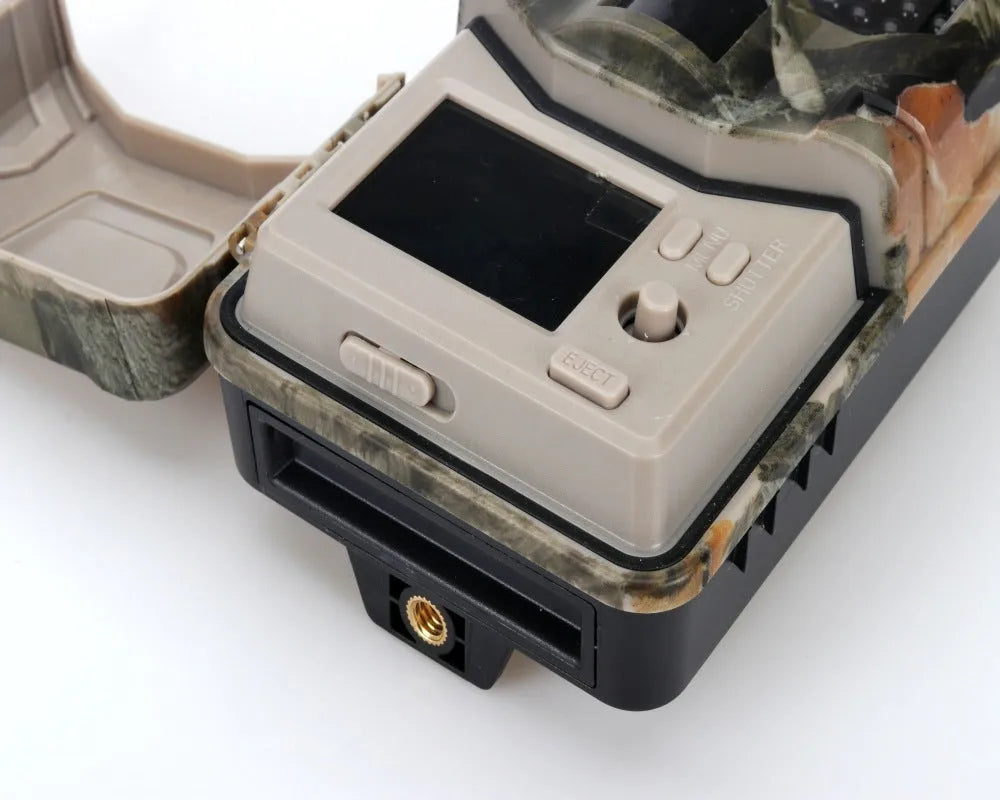 Camouflage trail camera with infrared LEDs, showing compact size for outdoor wildlife monitoring and security.