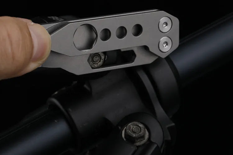 Titanium alloy multi-tool with crowbar edge, screwdriver tip, and bottle opener notches on a stone wash finish background.