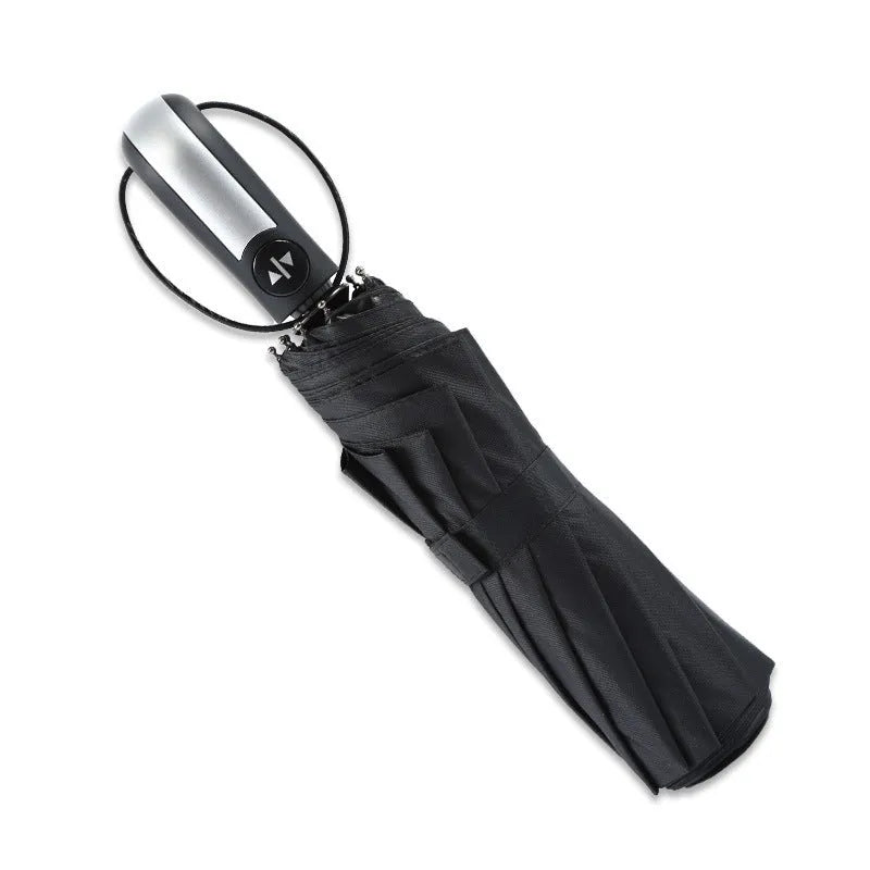 Open black automatic triple-folding business umbrella with a large canopy and rubber handle.