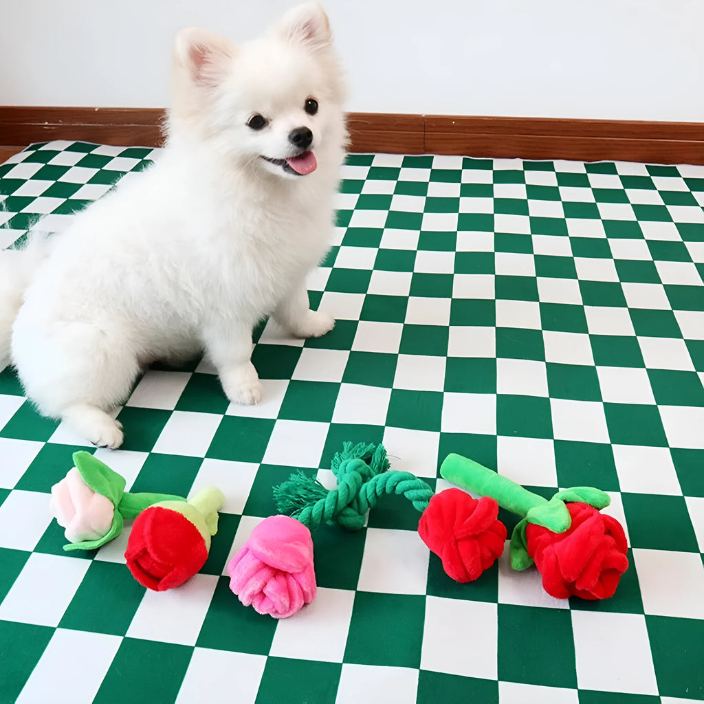 Plush pink rose flower dog chew toy with green leaf and a squeaker inside.