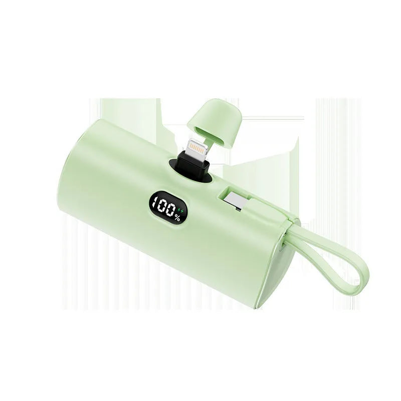 Capsule shaped digital display wireless power bank in multiple colours showing its compact size and built-in plug.