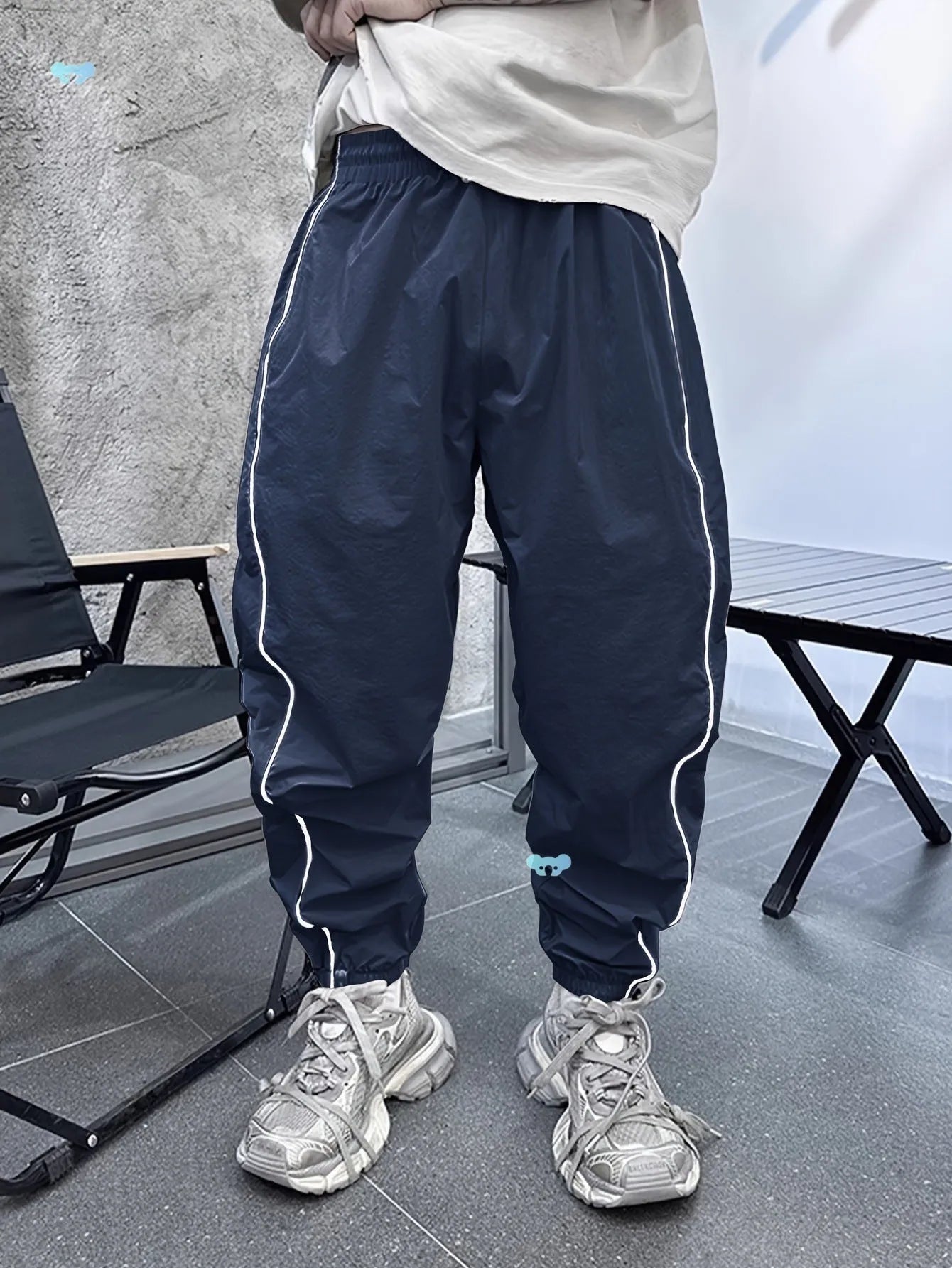 Men's blue bamboo fibre casual sports trousers with cropped length and loose fit on a hanger.