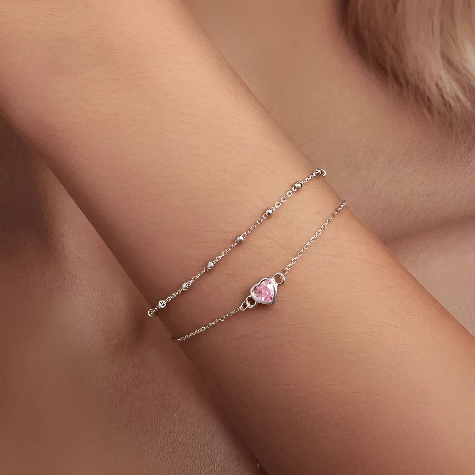 Women's sterling silver bracelet with a small heart-shaped pendant on an adjustable chain.