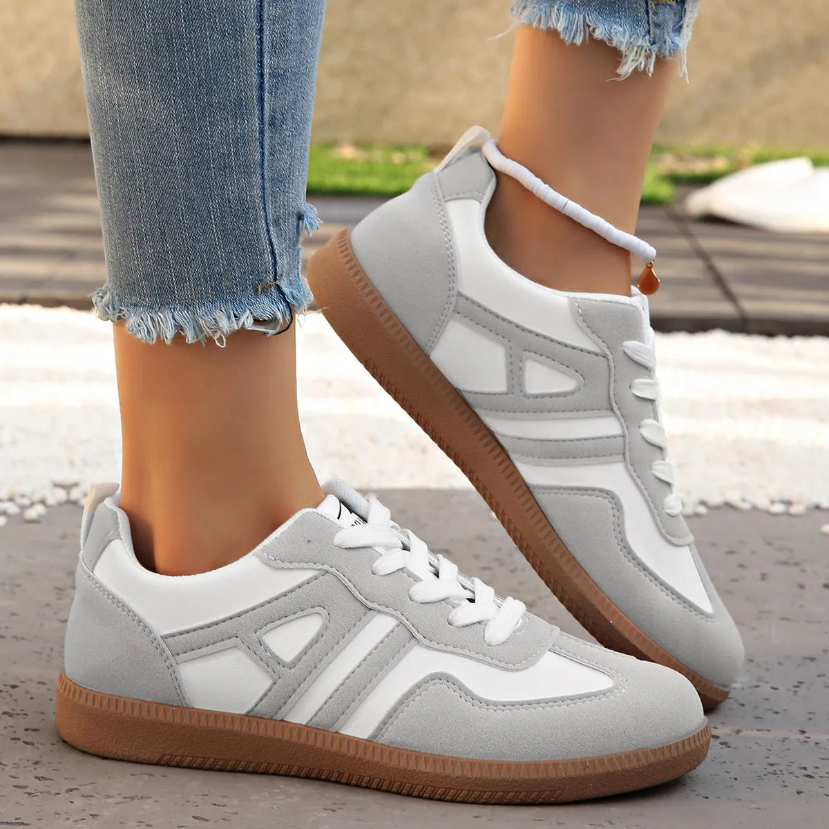 Retro lace-up women's jogging shoes in grey with a platform heel and cross strap detail.