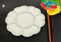 White hand-made ceramic plum blossom shaped artist palette for paint mixing.