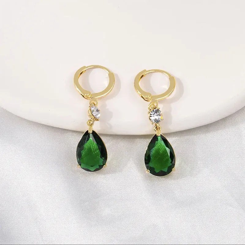 A pair of emerald green geometric teardrop alloy earrings on a plain background.