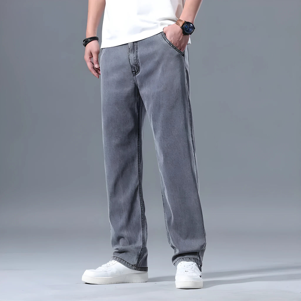 Man wearing light blue loose-fit straight-leg lyocell jeans with a zip fly