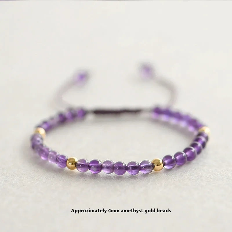 Handmade purple amethyst and 14K gold bracelet with 4mm round beads on a wrist.
