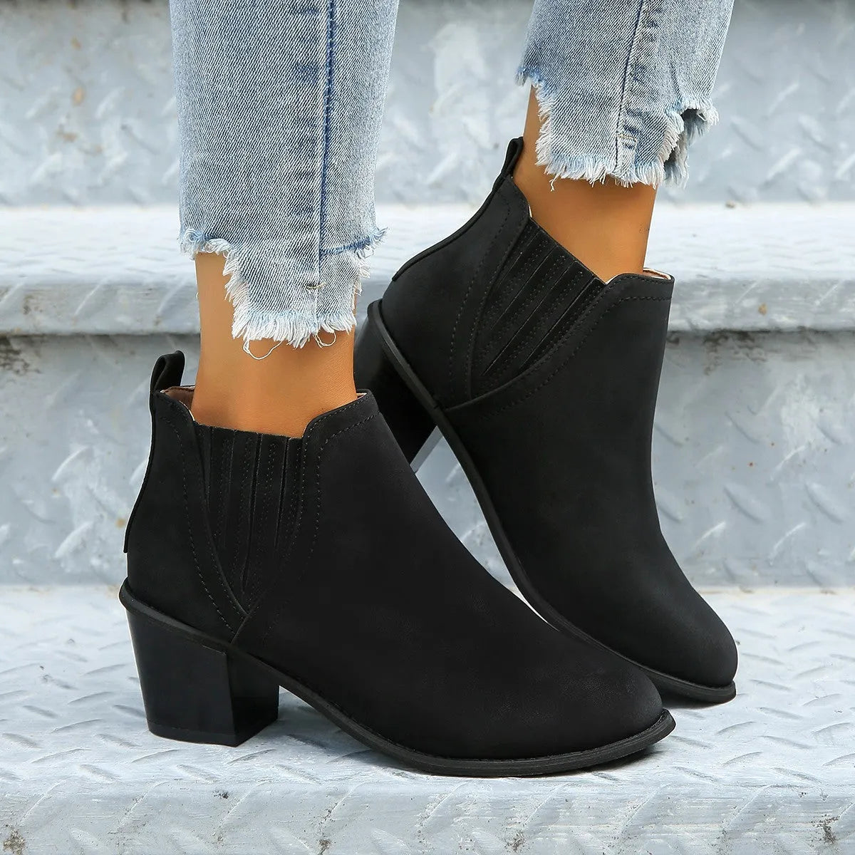 Black women's slip-on ankle boots with a pointed toe and thick square heel on a rubber sole.