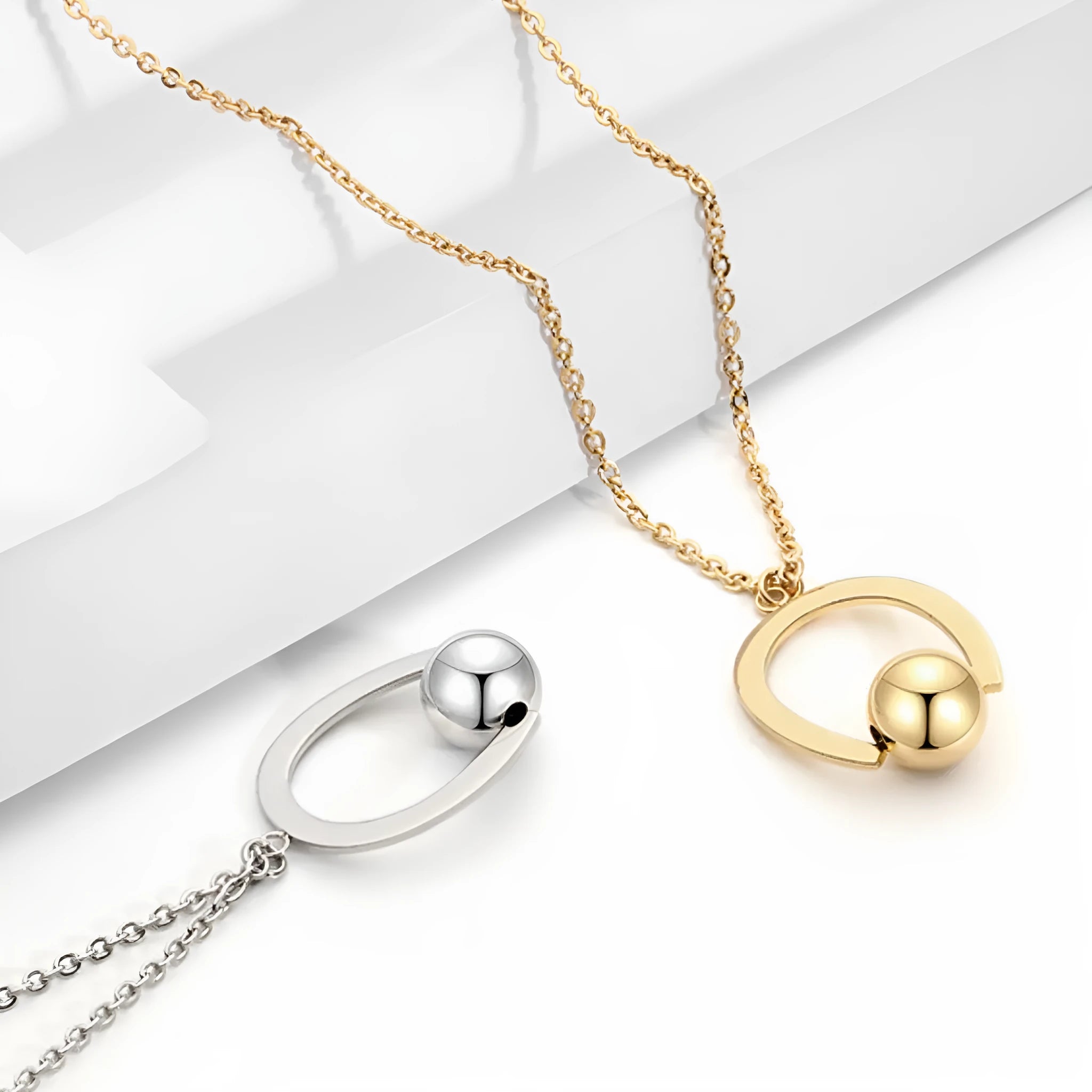 Gold tone stainless steel necklace with geometric pendant on a cross chain, shown adjusted to a medium length.