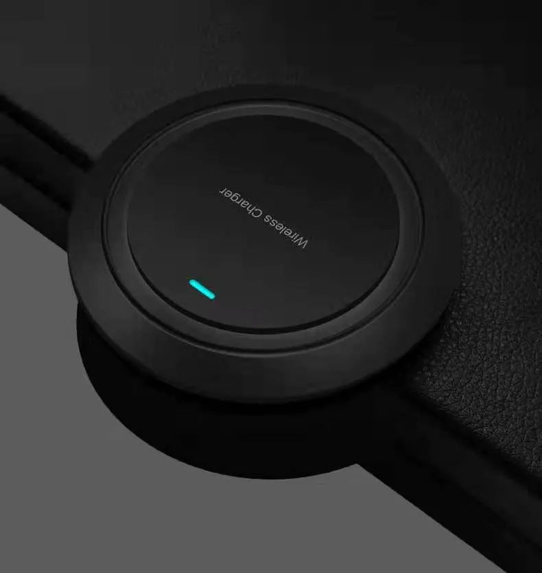 A round, slim 7mm thick 10W desktop wireless phone charger in black or white on a desk.