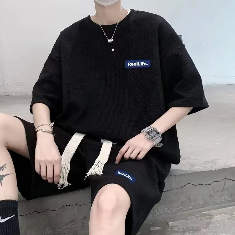 A waffle-textured leisure sports suit consisting of a short-sleeve top and shorts in a neutral colour.
