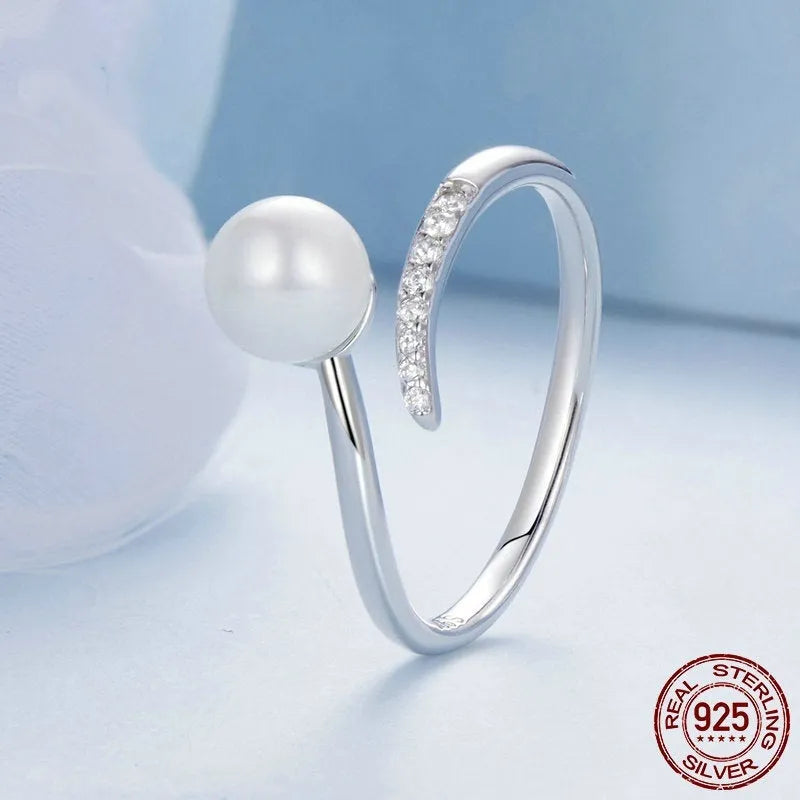 Silver-coloured adjustable open loop ring with a natural white shell pearl setting.