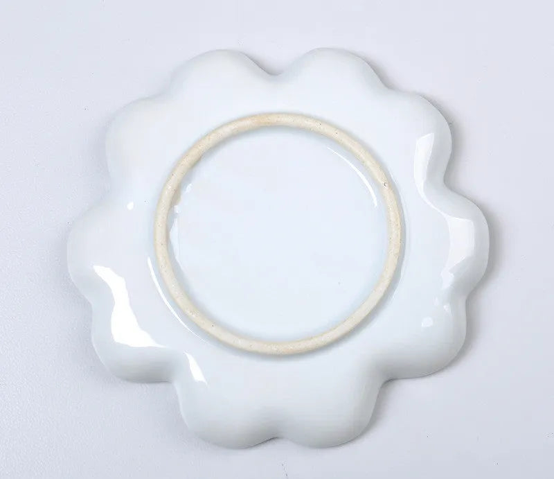 White hand-made ceramic plum blossom shaped artist palette for paint mixing.
