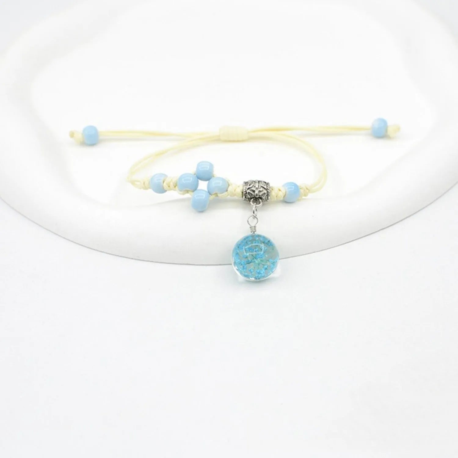 Hand-woven glass bracelet with large beads containing real dried flowers, shown in multiple colour options.