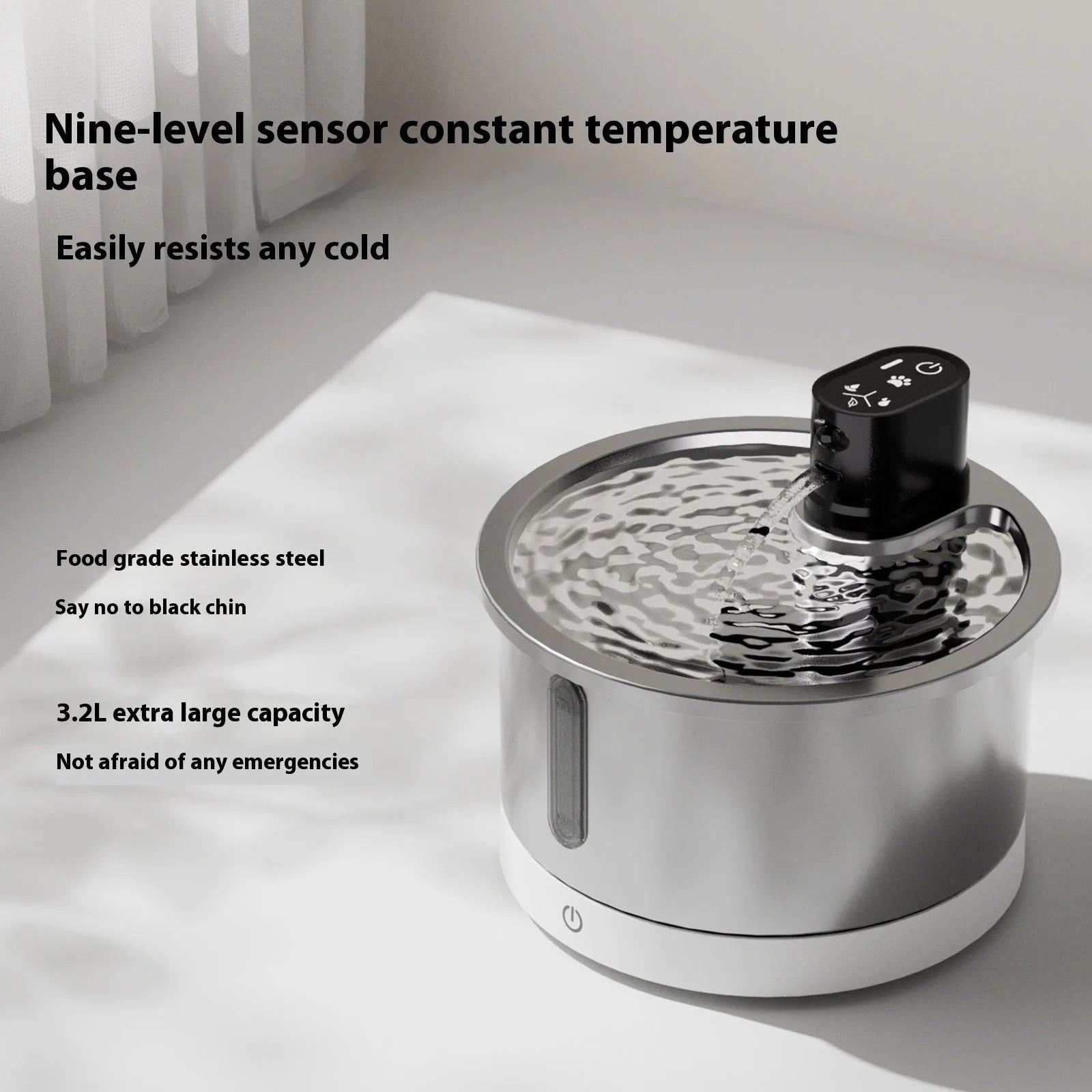 Stainless steel pet water fountain with a white heating base on a kitchen counter.