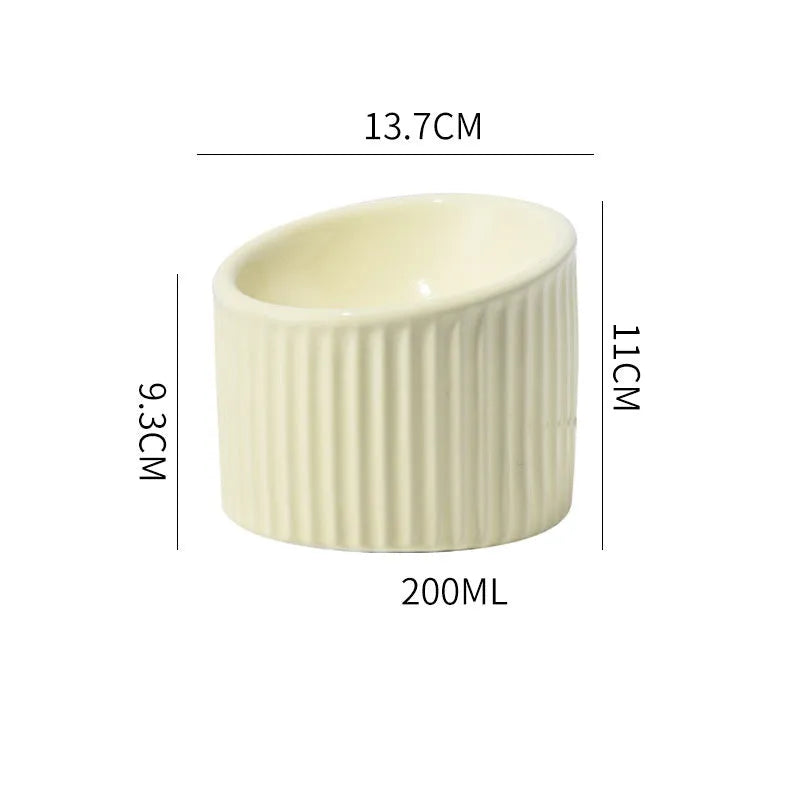 Elevated ceramic cat bowl in light green, showing tilted design and round whisker-friendly shape