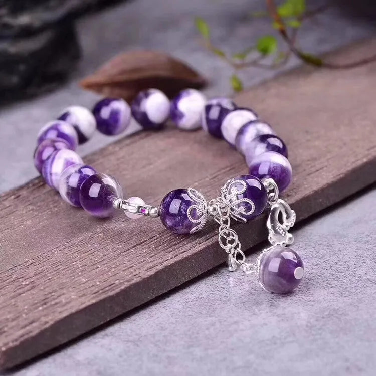 Purple amethyst gemstone bracelet with 10mm round beads on woman's wrist