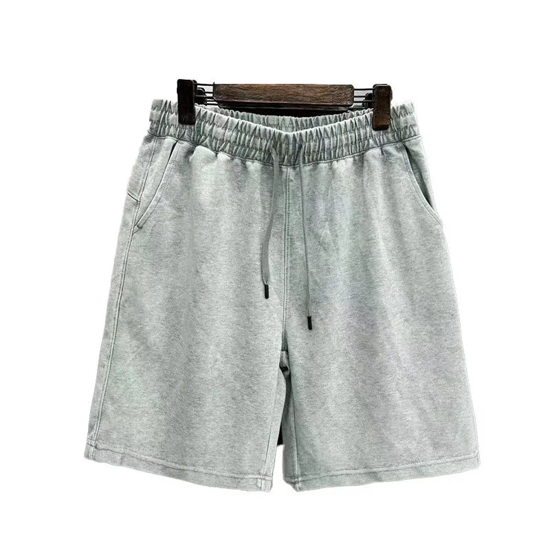 Man wearing loose-fit distressed cotton shorts in a solid colour.