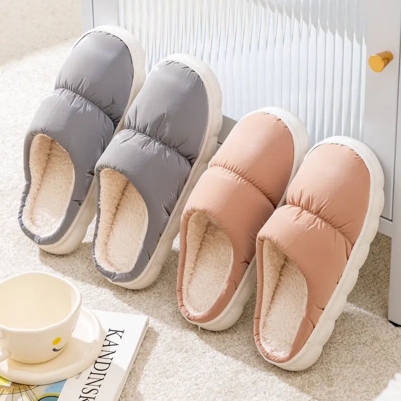 Blue down cotton winter slippers with a thick rubber sole and plush lining, shown on a wooden floor.