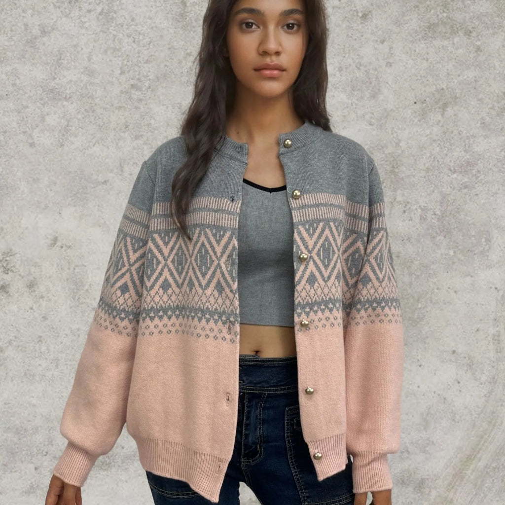 Woman wearing a grey alpaca wool cardigan with a long-sleeve diamond knit pattern in contrasting colours.