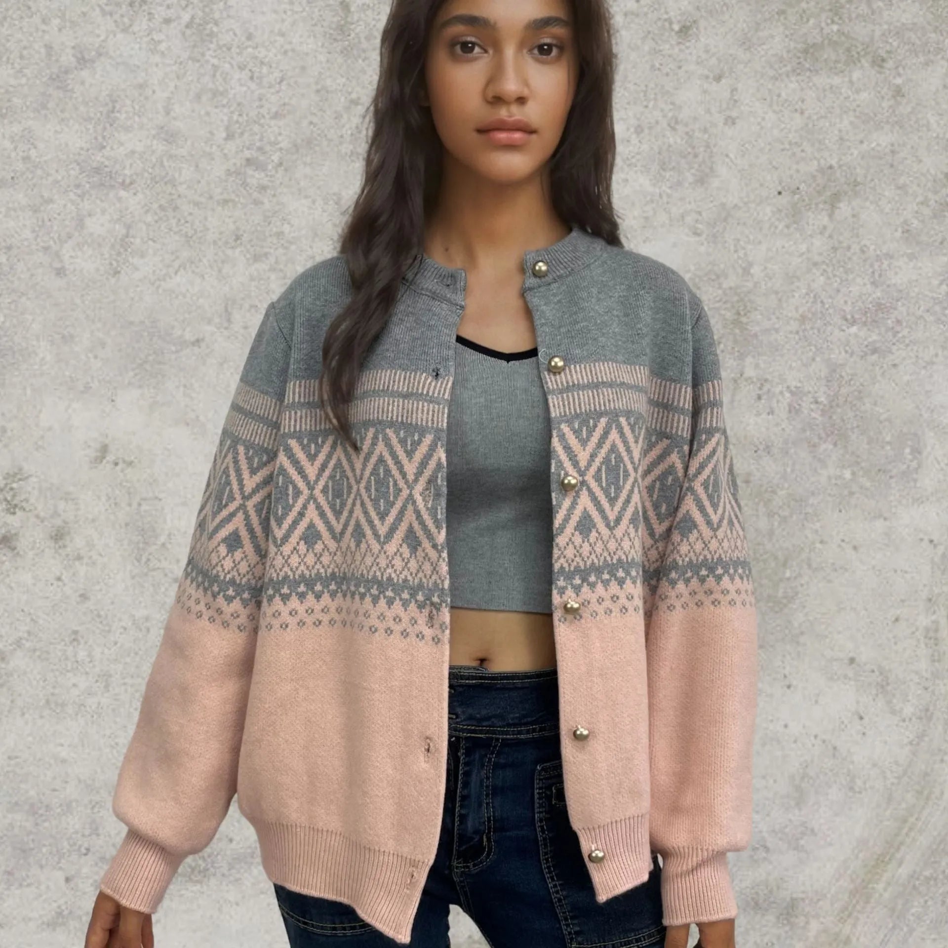 Woman wearing a grey alpaca wool cardigan with a long-sleeve diamond knit pattern in contrasting colours.