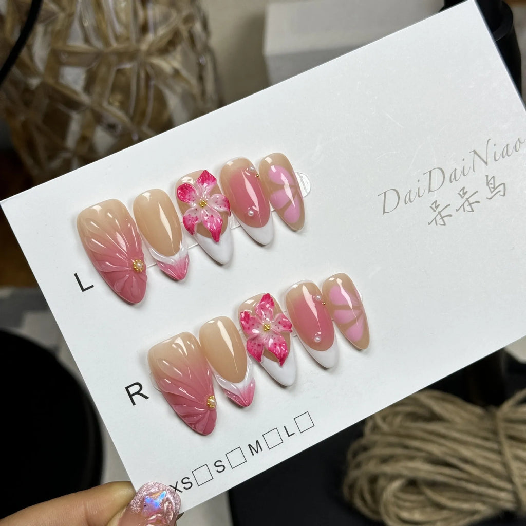 Set of white plastic almond-shaped nail tips with 3D raised lily and ice flower French manicure design.