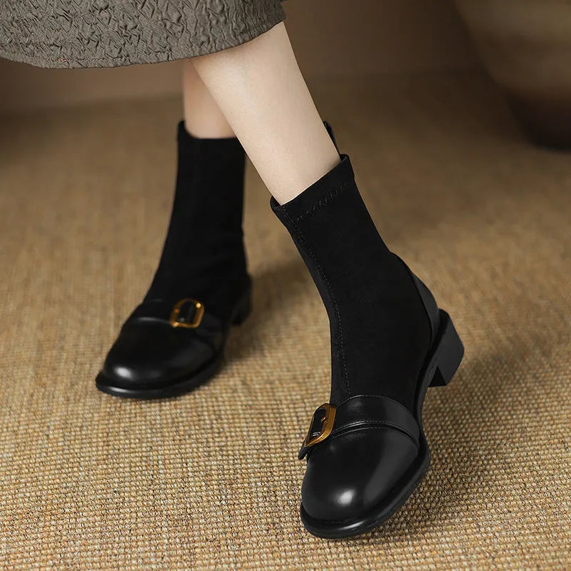 Black women's ankle boots with lace-up front and belt buckle stitching detail.