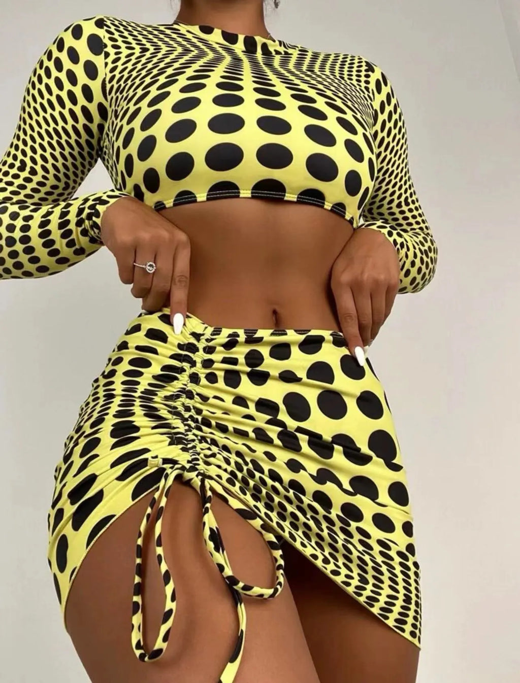 Green and yellow polka dot women's three-piece swimsuit set showing top, skirt, and bra.