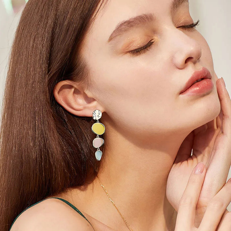 A pair of simple disc-shaped alloy earrings with a Morandi three-colour oil-drip wash finish.