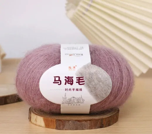 Ball of mohair yarn for DIY scarf knitting in one of 34 colours, including white, pink, blue, and green.