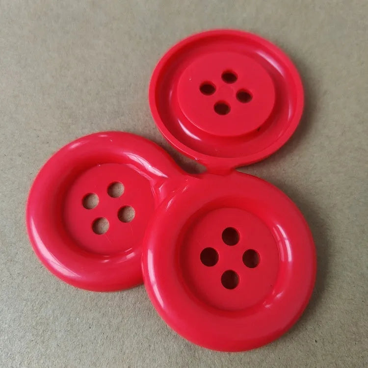 Oversized round edge plastic button with four holes in various colours and diameter sizes