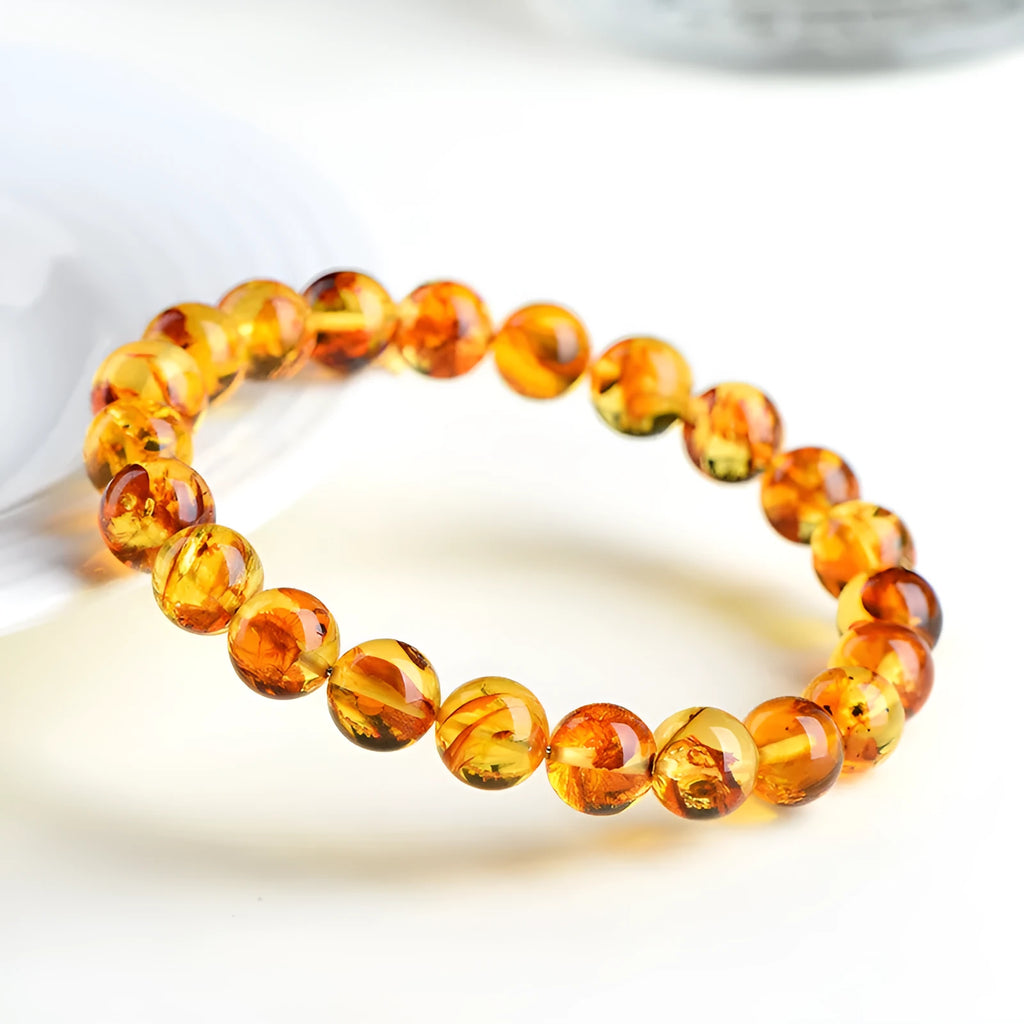 A geometric-bead amber bracelet with natural yellow piebald colouration on a wrist.