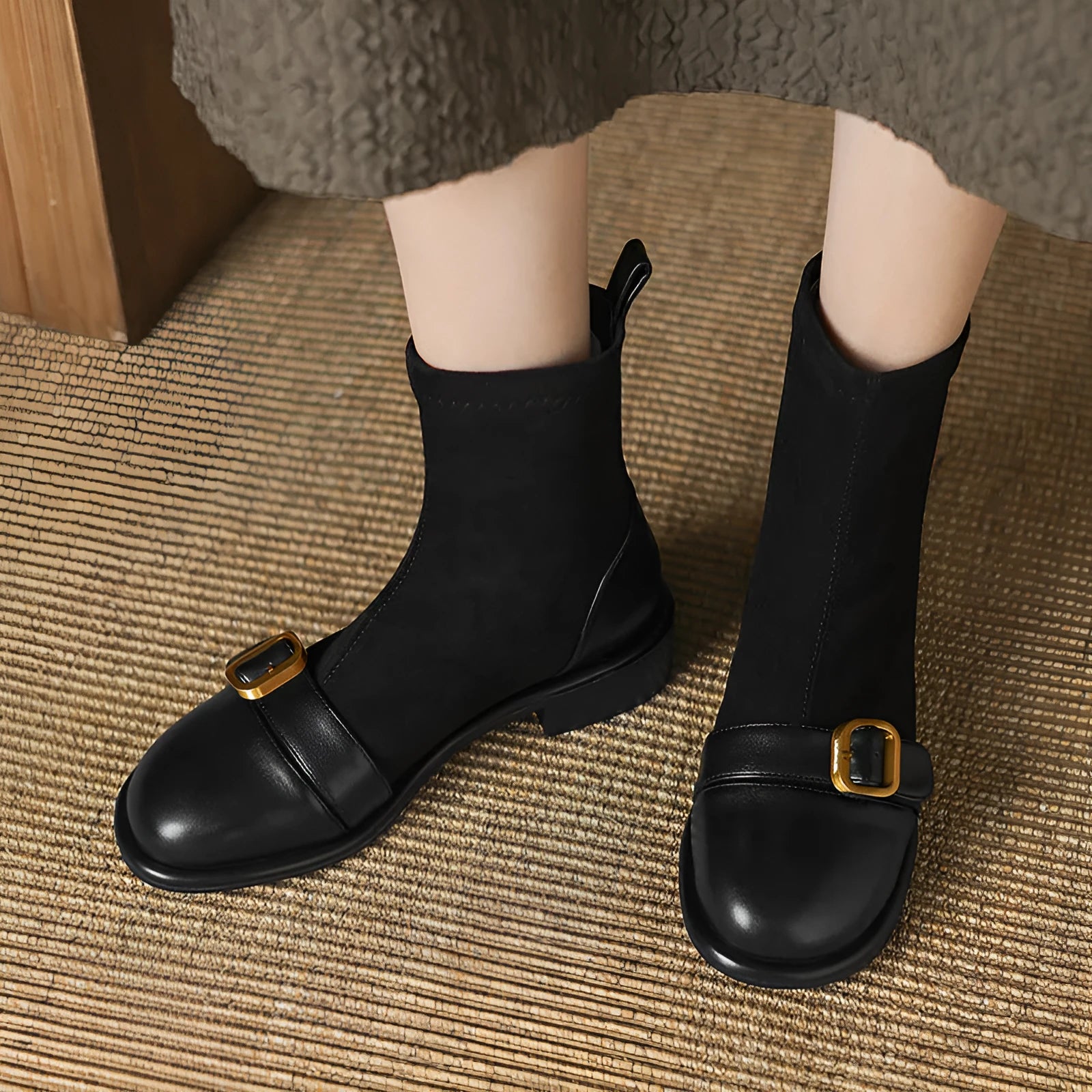 Black women's ankle boots with lace-up front and belt buckle stitching detail.