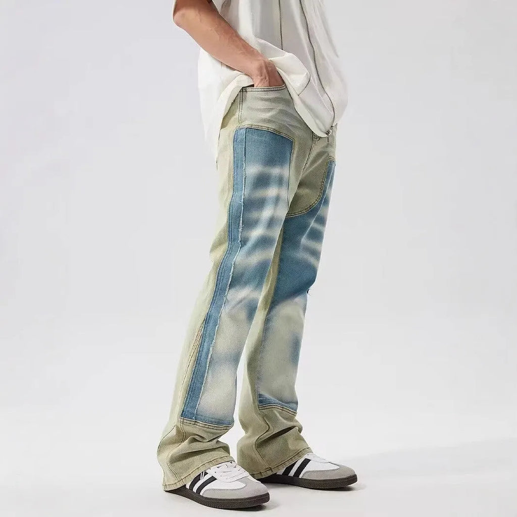 Yellow and blue retro patchwork jeans with splash-ink distressed design and zip fly.
