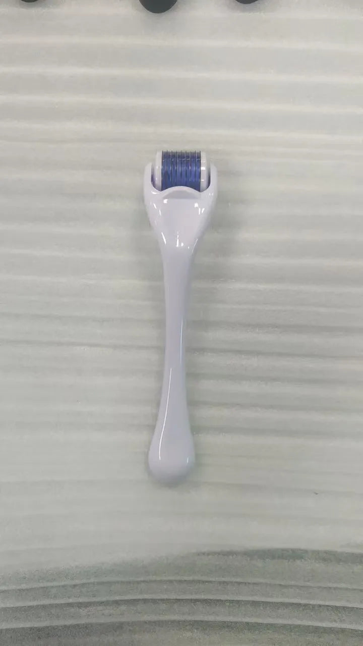 540 micro needle roller tool with black handle and coloured wheel on a white background.