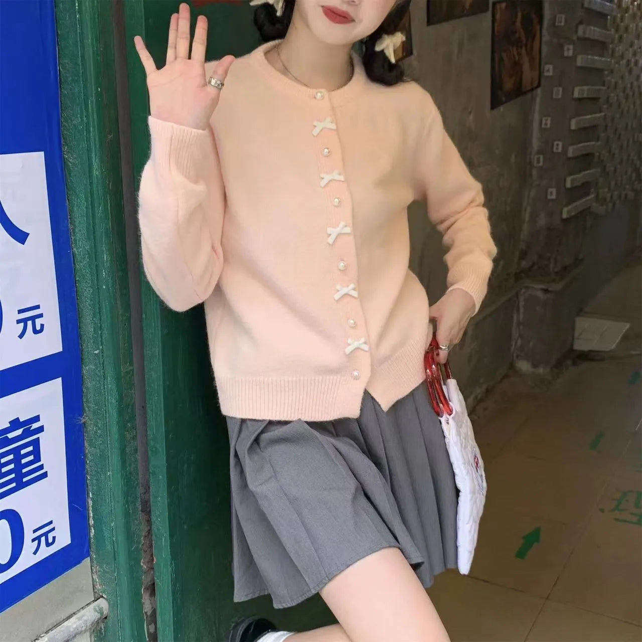 Women's cashmere cardigan sweater with bow accent and pearl buttons in nine colour options
