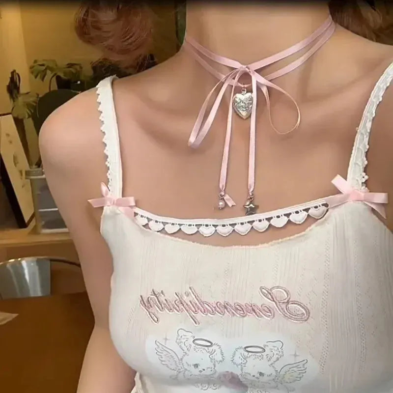 Close-up of a women's alloy fashion necklace with a love pendant and ribbon detail on a delicate clavicle chain.