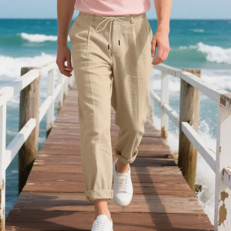 Man wearing light khaki linen casual trousers with a drawstring waist and straight-leg fit.