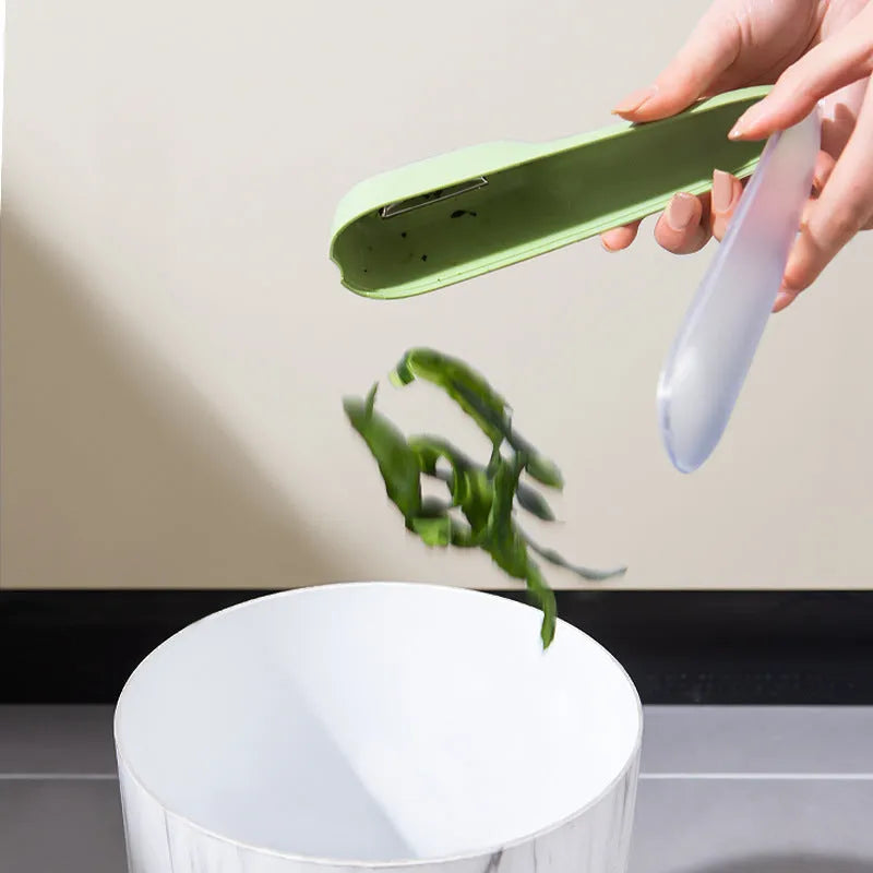 Green kitchen peeler with a stainless steel blade stored inside its transparent plastic tube.